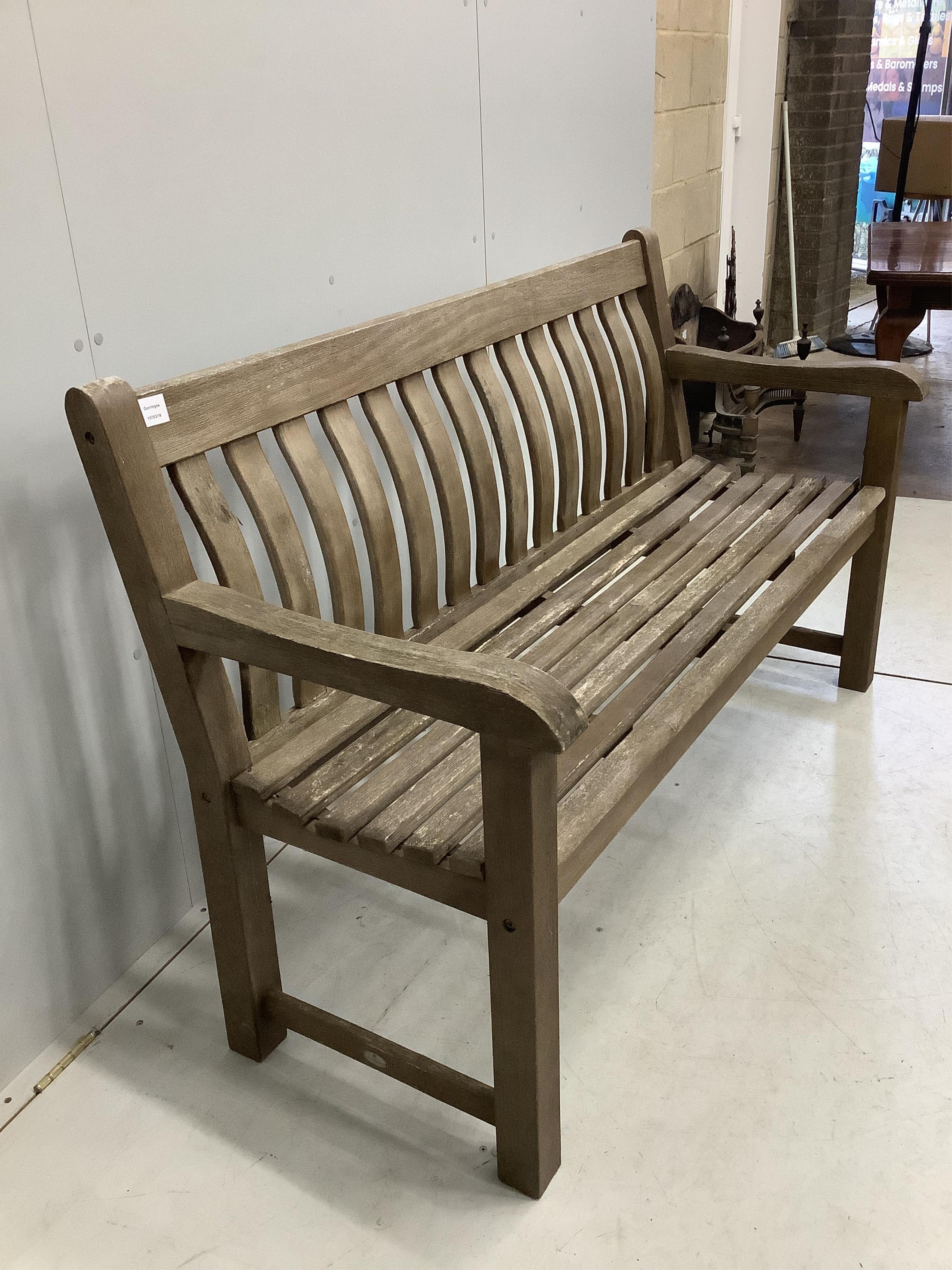 A weathered teak slatted garden bench, width 146cm, depth 52cm, height 92cm. Condition - good but weathered